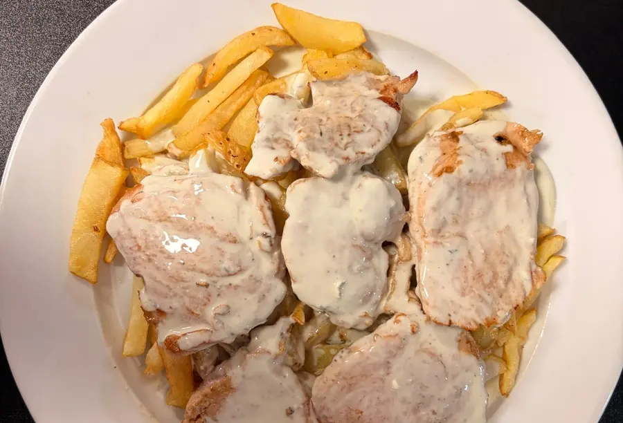Medallones de cerdo con salsa casera y patatas fritas en Mesón Los Monteros