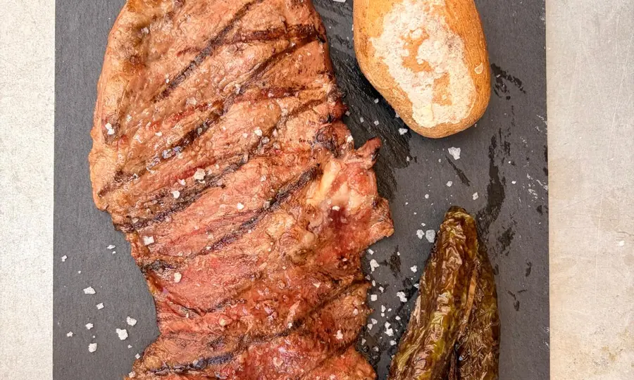 Pluma ibérica a la brasa con patata asada y pimiento de padrón